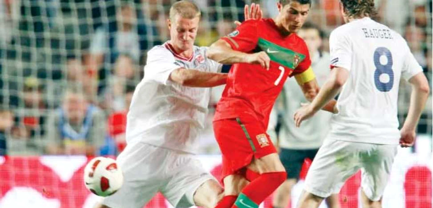 Cristiano Ronaldo (în roşu) a fost greu de ţinut  de către fundaşii naţionalei Norvegiei   
