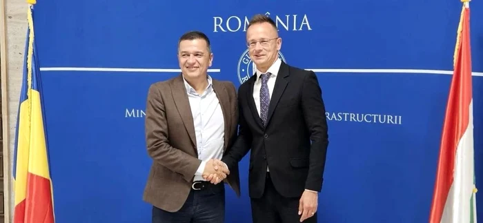 Ministrul Transporturilor, Sorin Grindeanu, și Peter Szijjarto în timp ce își strâng mâna.