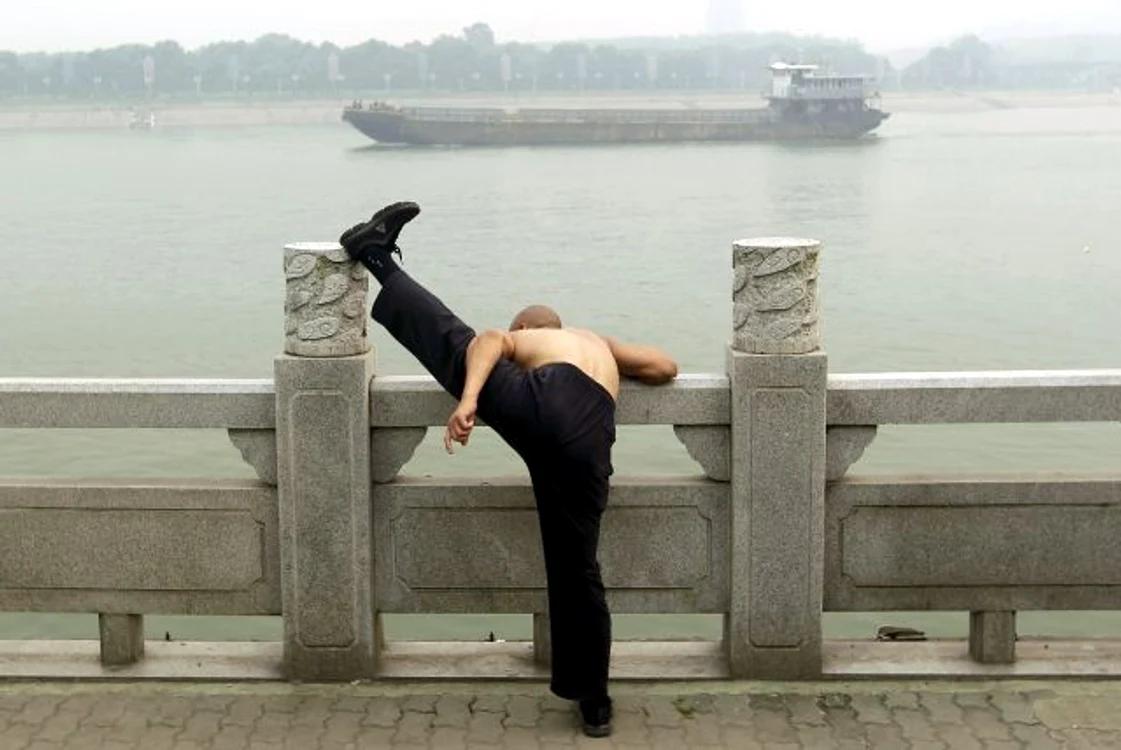 Un bărbat face exerciţii fizice pe malul râului Han, în oraşul chinez Wuhan