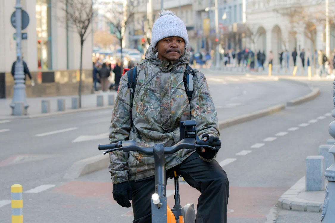 Curier cu bicicletă și rucsac de livrări, fotografiat pe o stradă din București