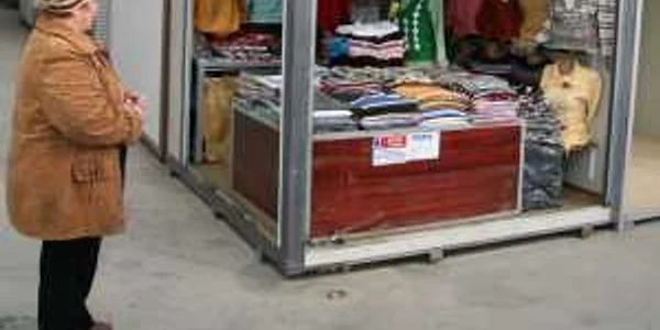 Un comerciat îşi aranjează marfă într-un modul din Bazarul Suceava