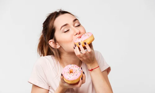 Gogosi -dulciuri - tanara mananca desert FOTO SHUTTERSTOCK