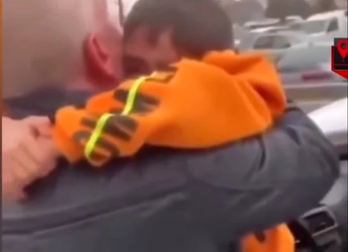 Tatăl își îmbrățișează copilul cel mic scos de sub dărâmături