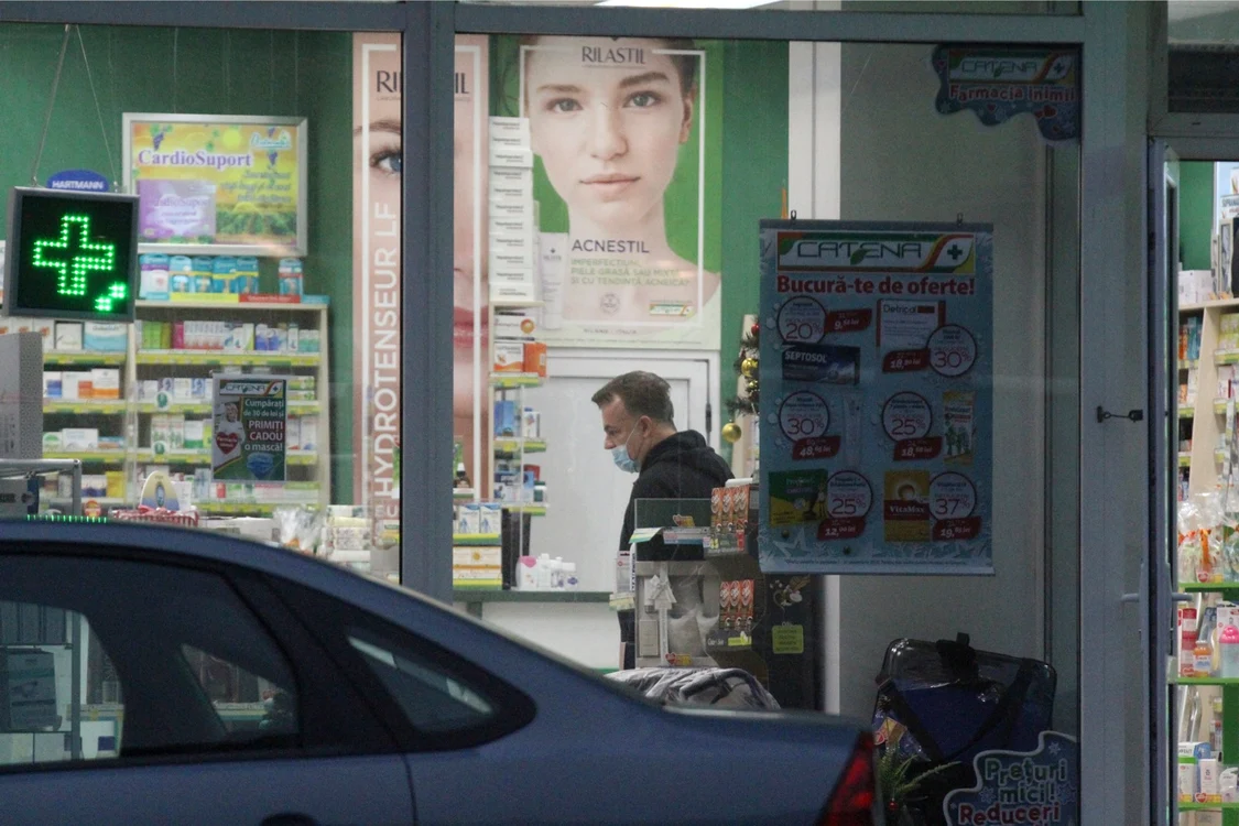 Adrian Enache, pentru câteva momente, cu masca sub nas, în interiorul farmaciei
