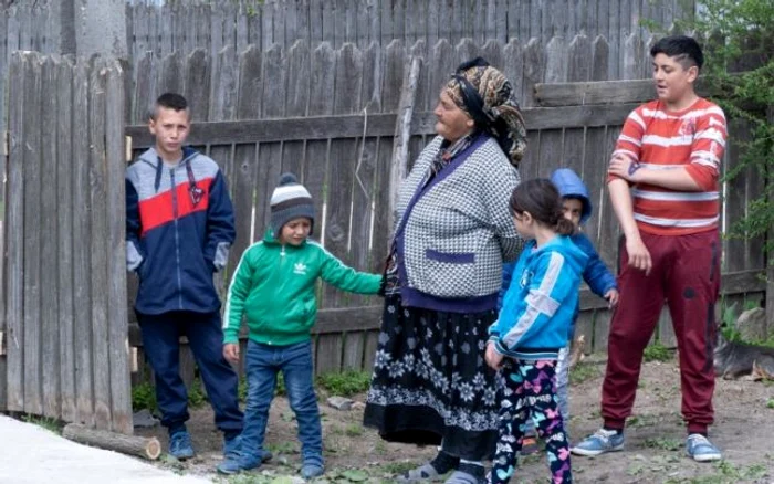 Bunica şi cei trei micuţi privind casa primită în dar FOTO Aurel Coman