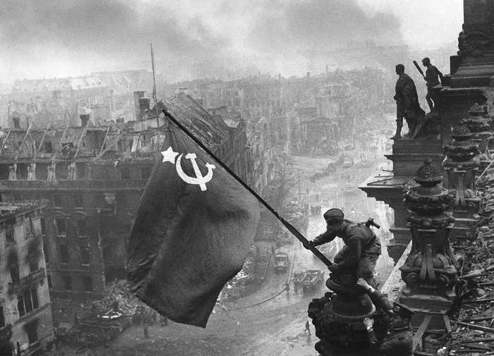 Un soldat din Armata Roșie flutură steagul pe clădirea Reichstag FOTO Evgheni Khaldei
