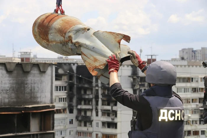 Ucrainieni
coboară o bombă rusescă neexplodată de pe un bloc din Harkov, Ucraina. FOTO EPA-EFE