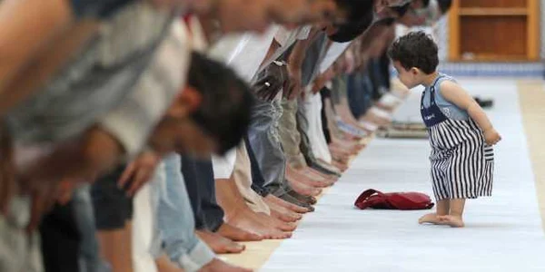 un copil se plimba printre musulmanii care fac rugaciunea de pranz in marea moschee din Strasbourg foto reuter