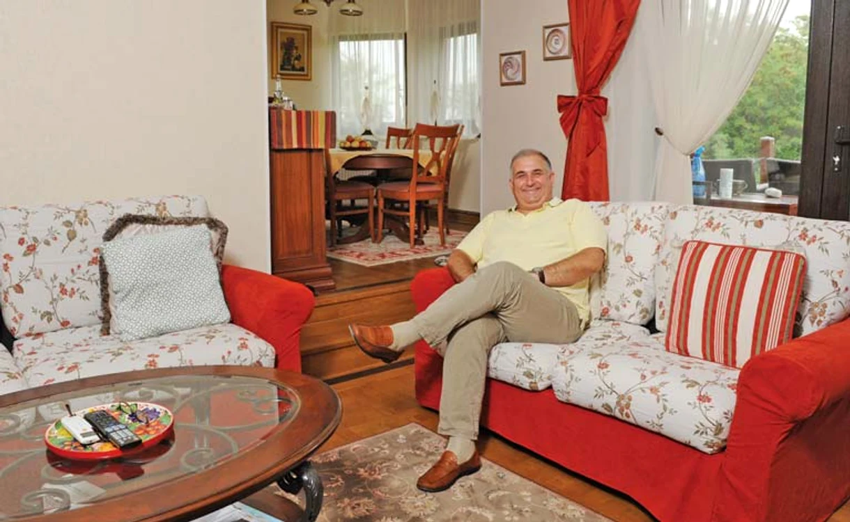 Livingul lui Horia Vîrlan este mare, primitor, iar în fundal se vede locul în care familia se strânge la masă