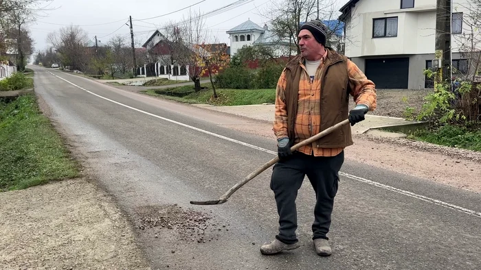 Nicolae strânge pietrele împrăștiate de camioane ca să nu-i ajungă în curte FOTO: Oana Șlemco