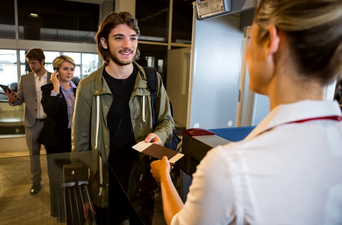man queue receiving passport boarding pass jpg