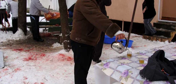 O ţuică fiartă servită pe lâmgă porcul proaspăt sacrificat