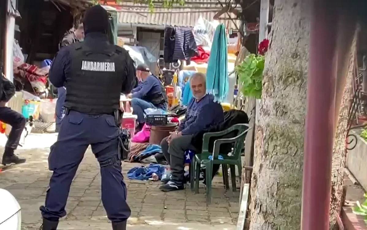 
    Vasile Lavric (pe scaun în plan apropiat) a fost păzit pe tot timpul perchezițiilor de jandarmi înarmațiFoto: captură stirileprotv.ro  