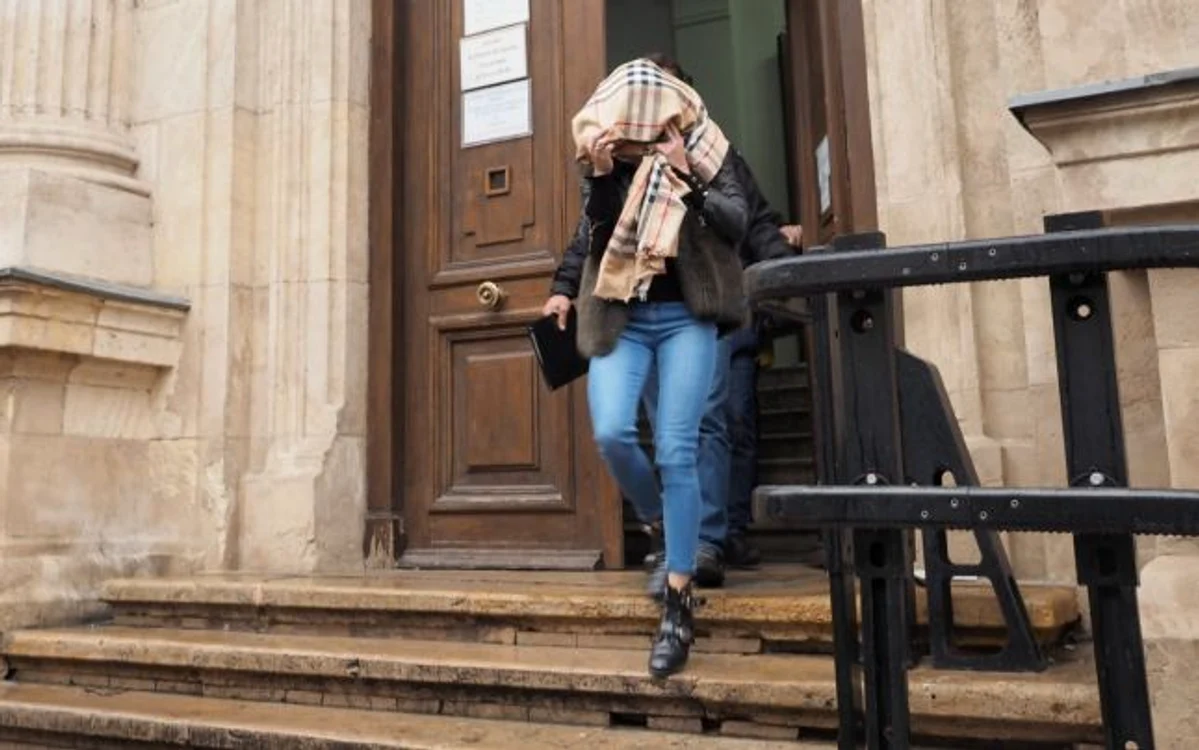 O femeie judecată, apoi ulterior condamnată într-un dosar de infracţiuni cibernetice îşi ascunde faţa la ieşire din instanţă Imagine: Ionuţ Mureşan