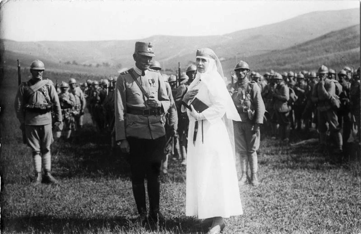 Regina Maria discută cu un general român în faţa trupei.