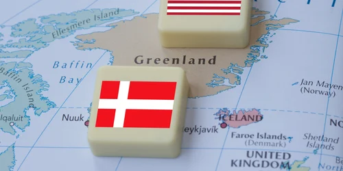 Hartă a Groenlandei pe care se află blocuri cu steagurile SUA și Danemarcei FOTO Shutterstock jpg