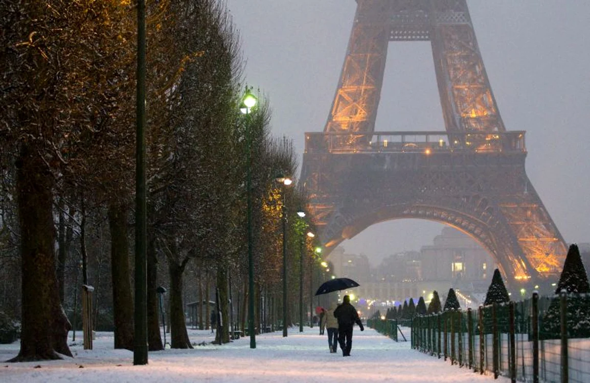 Parizienii se bucură de zăpada aşternută în preajma Turnului Eiffel (Foto: EPA)
