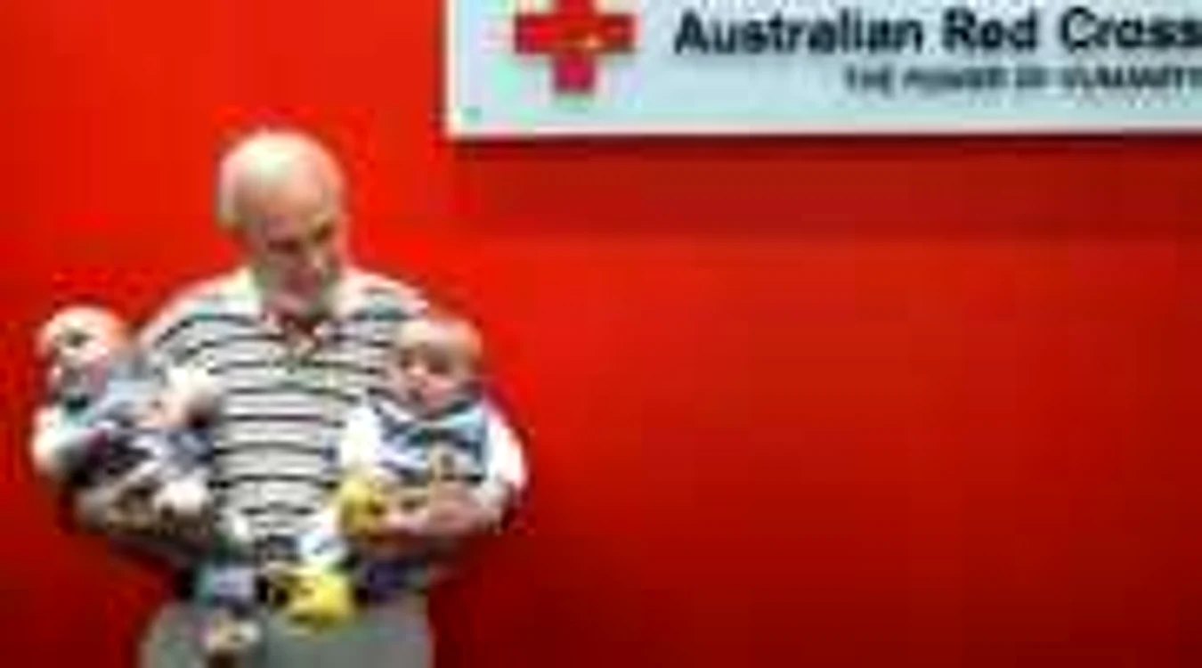 Australianul ţine în braţe doi dintre copii ale căror vieţi au depins de sângele său