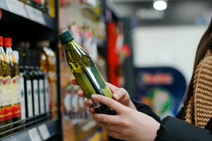 foto femeie care cumpără ulei în supermarket