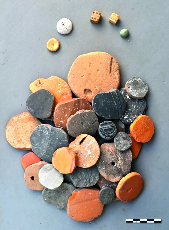 Jetoane din diferite materiale şi zaruri descoperite în clădirea C3 din castrul auxiliar de la Porolissum/Moigrad, judeţul Sălaj (fotografie realizată de Constanze Höpken)