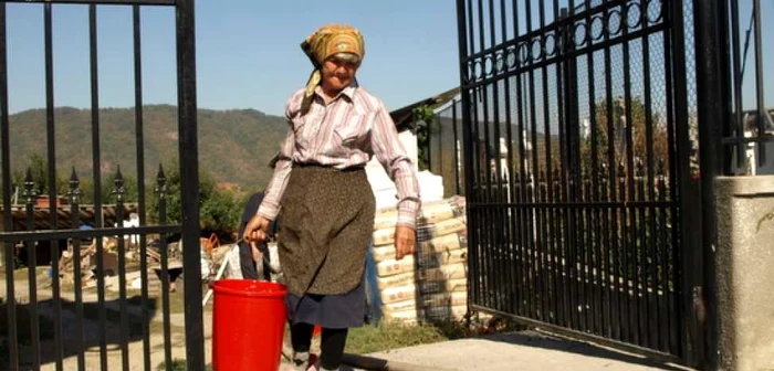 Oamenii au umplut gălețile cu apa adusă de pompieri. Foto: Daniel Guță