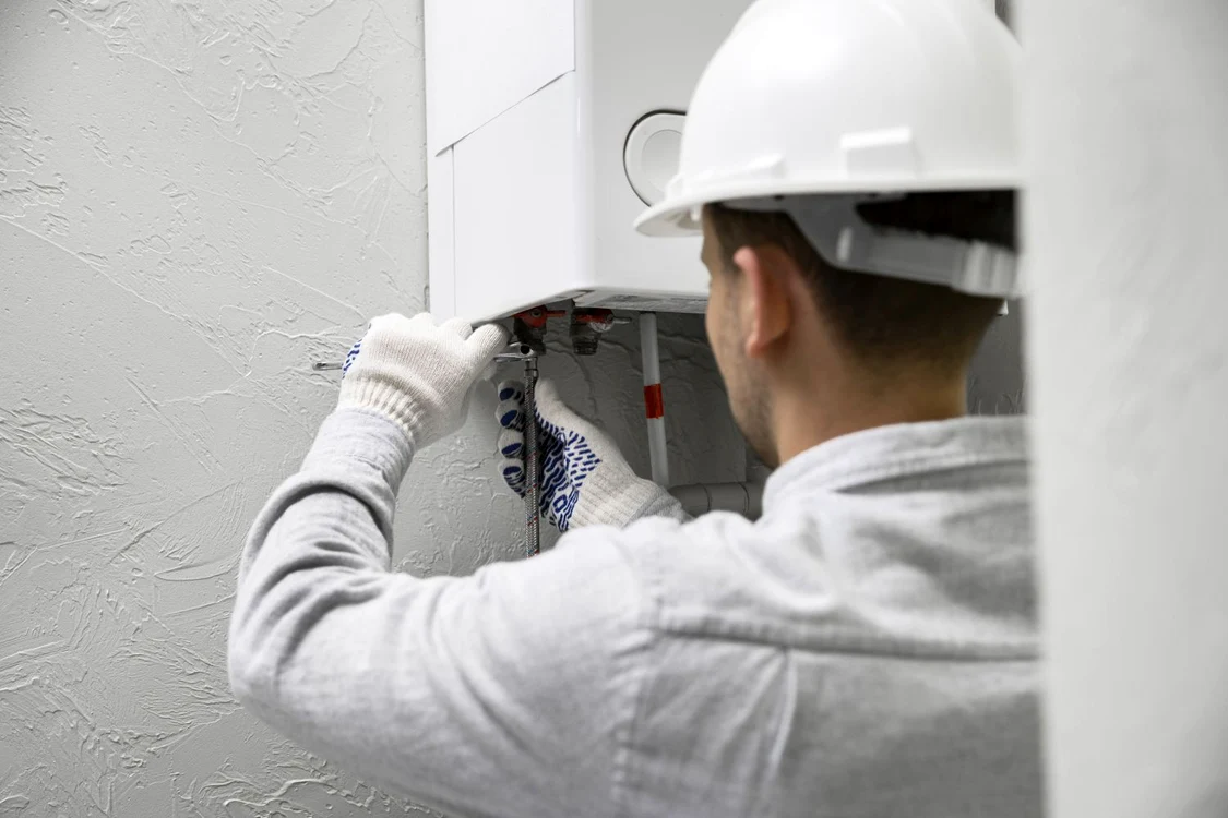 Un instalator verifică o centrală de apartament