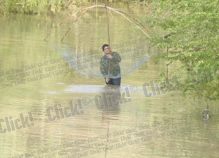 Un bărbat din Vârtoape, surprins de fotoreporterii Click! cu plasa pe viitură (FOTOGRAFII: DORIN CONSTANDA)