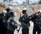 Un poliţist israelian aruncă cu gaz lacrimogen spre palestinienii care aruncă cu pietre FOTO Reuters