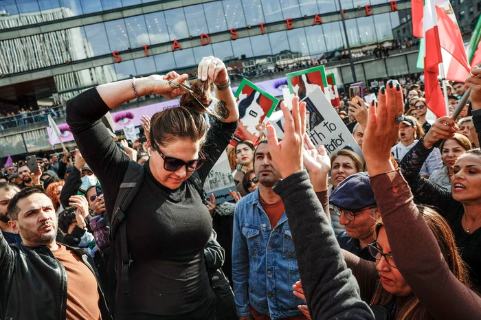 O femeie își taie părul la o demonstrație în Suedia, după moartea Mahsei Amini FOTO EPA-EFE