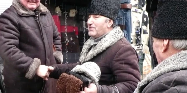 Ion Grămadă (centru) şi-a făcut mulţi prieteni de când vinde căciuli în Bazar