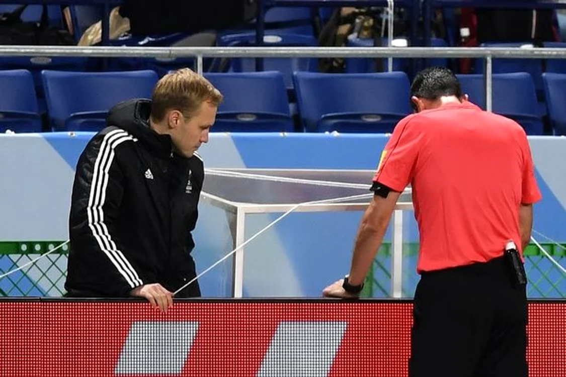 
    Arbitrul Kassai, cu spatele, urmăreşte reluările la televizor  