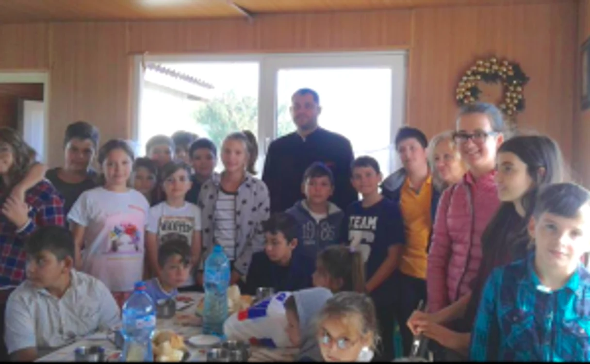 Preotul Viorel Dădârlad, în mijlocul copiilor din Amzacea Sursa Arhiepiscopia Tomisului