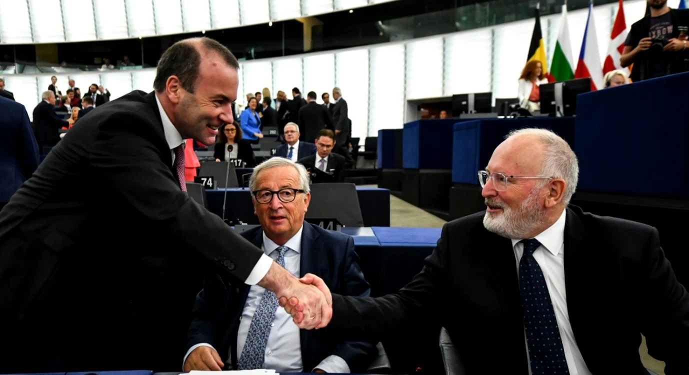 Manfred Weber, stânga, dând mâna cu Frans Timmermans. Niciunul nu a reuşit să-i ia locul lui Jean-Claude Junker (centru), deşi au fost favoriţi FOTO EPA-EFE