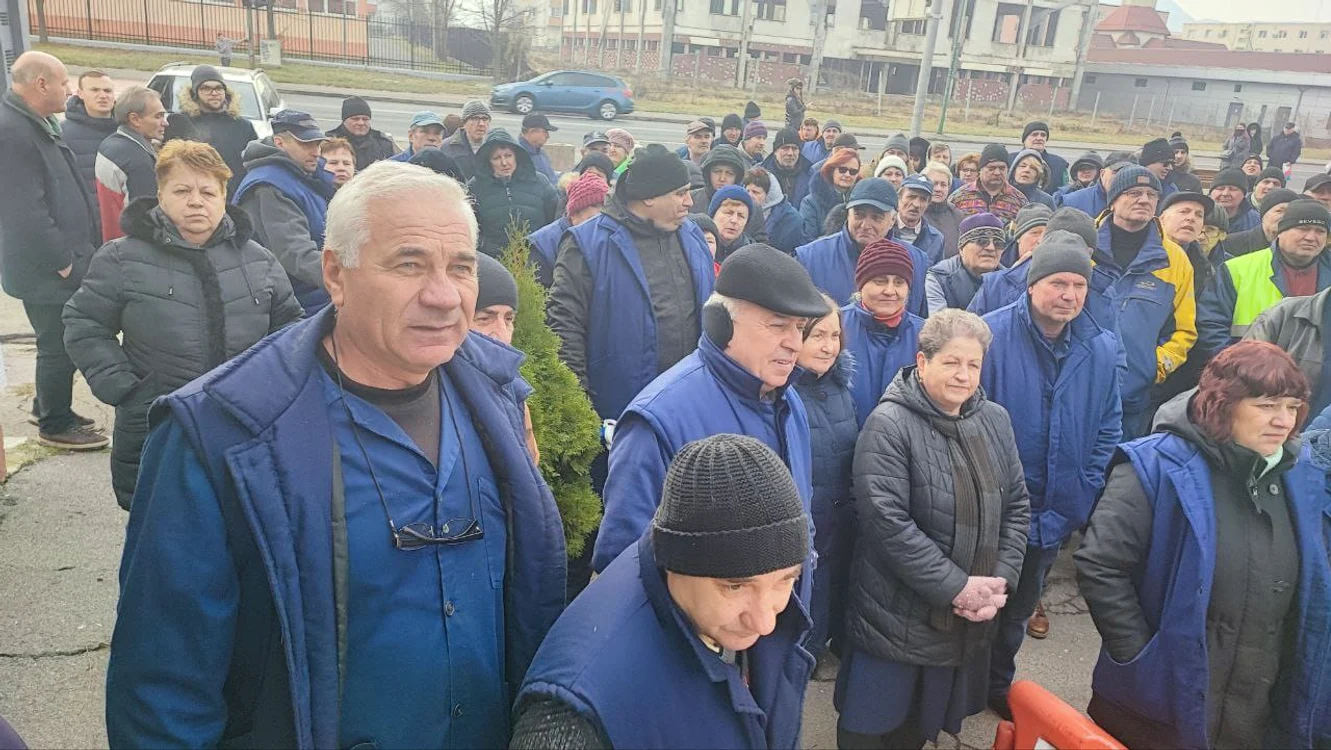 Angajați din industria de apărare, în salopete, protestând în curtea fabricii