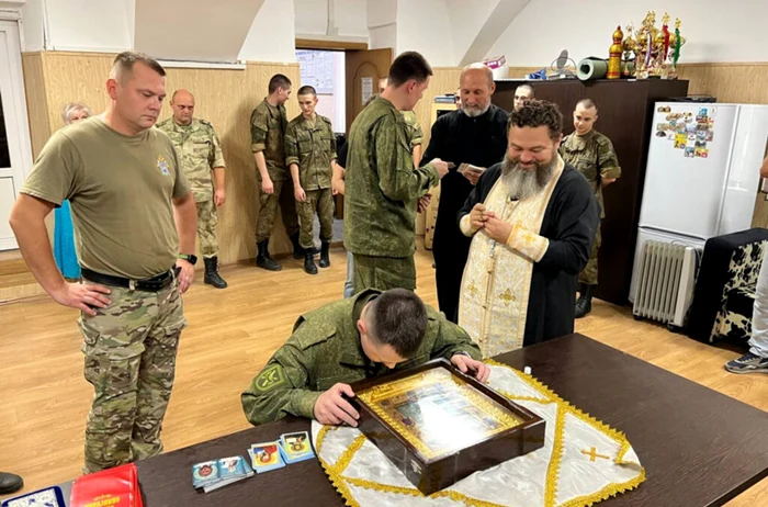 Soldați ruși rugându-se la Icoana „Îmblânzirea inimilor rele”. Sursă foto: The Insider