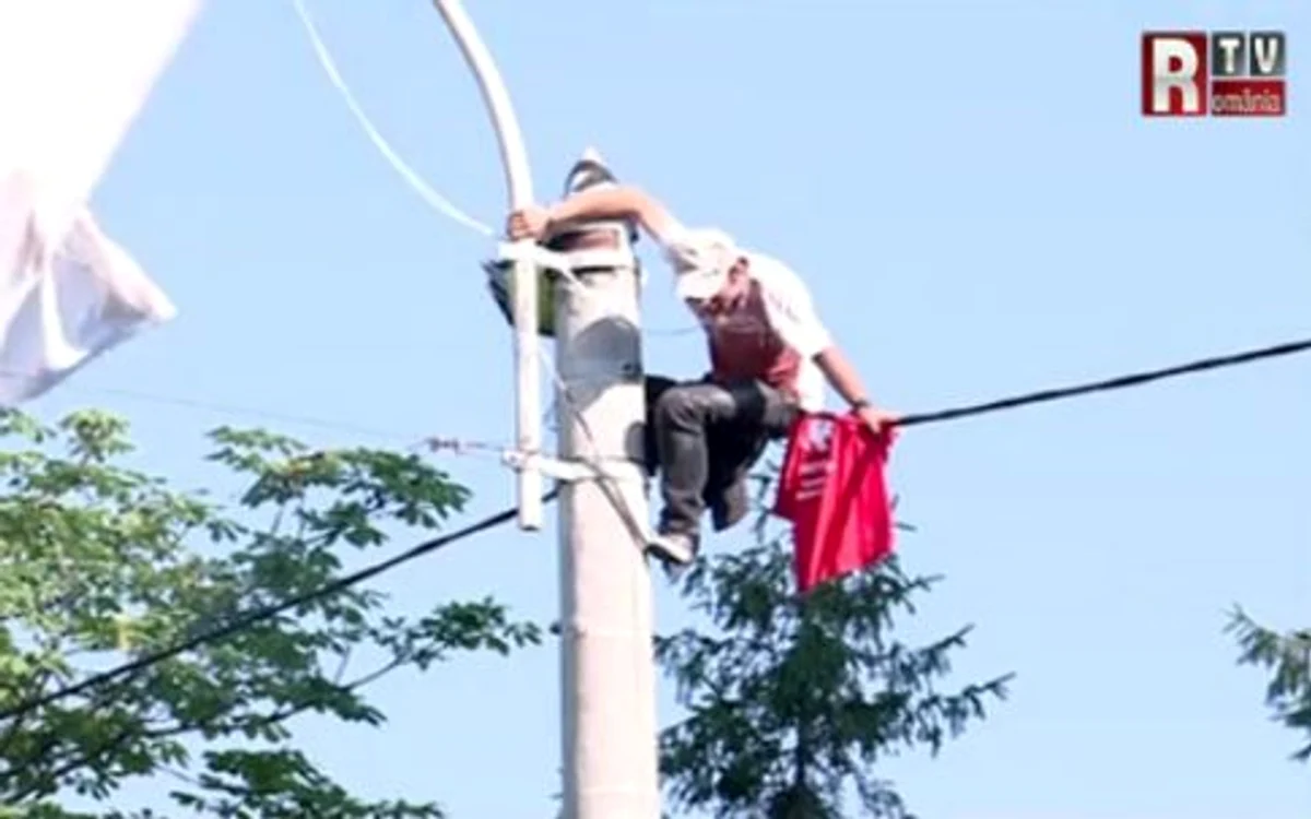 Omul protestează în faţa Palatului Cotroceni, pe un stâlp
