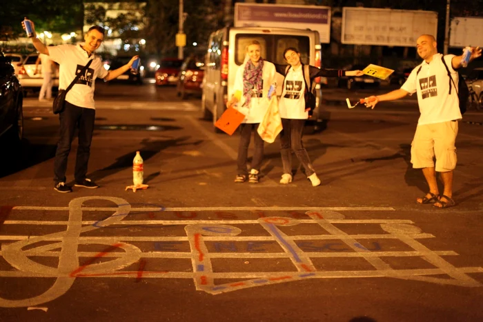 Voluntarii EBienale, după ce au desenat un portativ, cheia-sol şi notele muzicale, în parcarea unde va fi amplasată Piaţa Festivalului „George Enescu“ FOTO Lorena Codreanu/EBienale