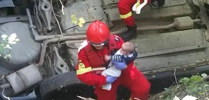 Copil salvat dintr-un accident, purtat cu grijă de pompieri FOTO Arhiva