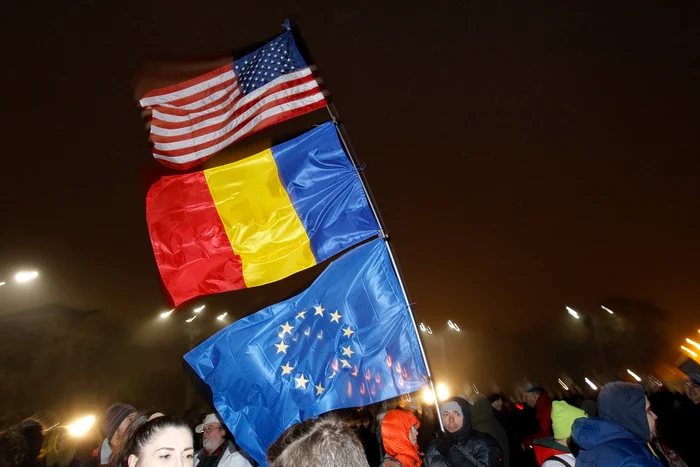 Pe verticală, de sus în jos, steagul SUA, steagul României și cel al Uniunii Europene