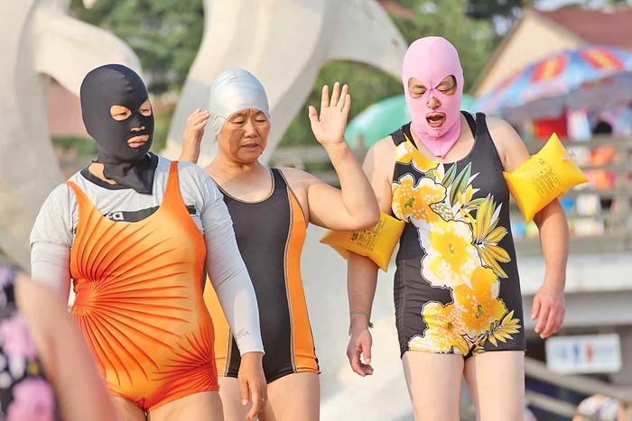 
    Îşi trag pe cap o mască, dar şi un costum care le acoperă întreg corpulFoto: Afp  