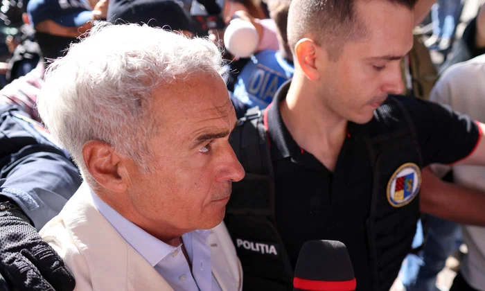 Călin Georgescu este însoțit de ofițeri de poliție la sediul DIICOT pentru audiere, în București. FOTO Inquam Photos / George Călin