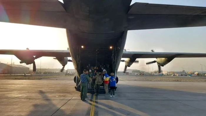 
    Românii, la îmbarcarea în avionul Hercules care îi aduce în țarăSursa foto: MApN  