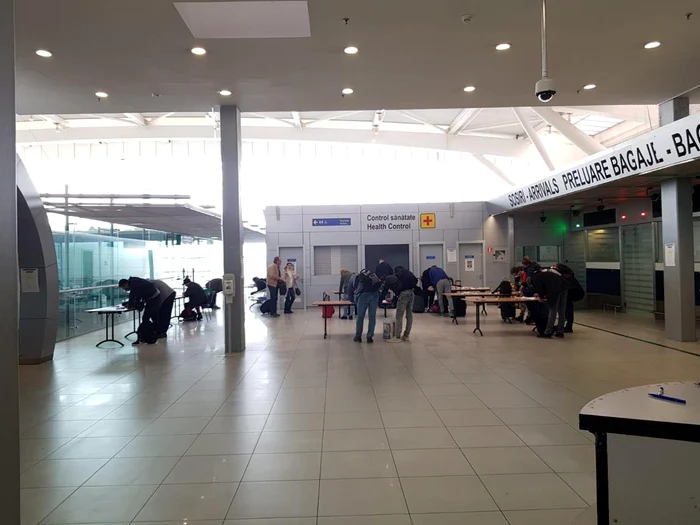 Pasagerii sosiți pe Aeroportul Otopeni completează chestionare cu datele pesonale. Acum, nimeni nu se mai înghesuie