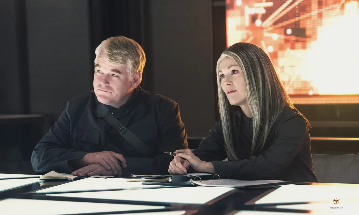 Philip Seymour Hoffman, alături de Julianne Moore, într-o scenă din „Jocurile foamei: Revolta“ FOTO cinemagia.ro