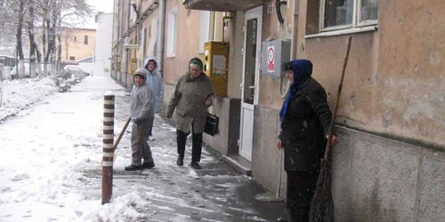 Oamenii au ieşit la curăţat zăpada dintre blocuri   