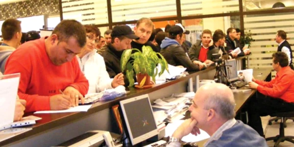 Oamenii aşteaptă să le vină rândul la ghişeu