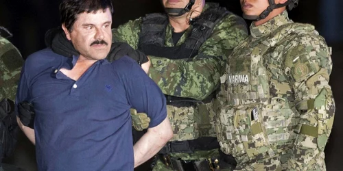 Joaquin El Chapo Guzman încătuşat e prezentat presei în timp ce e escortat spre elicopter de soldaţi mexicani lângă un hangar federal în capitala Mexicului FOTO AP