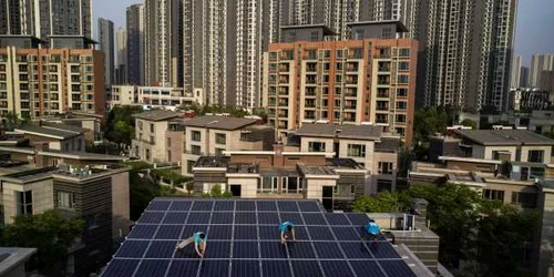 Muncitorii chinezi ai companiei  Wuhan Guangsheng Photovoltaic instalează panouri solare pe o clădire din Wuhan. FOTO Guliver/Gettyimages