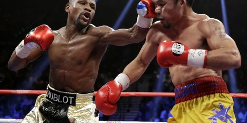 Floyd Mayweather Jr.(S) îl loveşte pe Manny Pacquiao în timpul meciului de box la categoria supermijlocie. FOTO AP