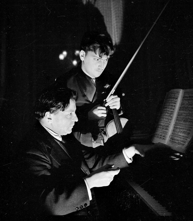 George Enescu cântând la pian alături de un violonist